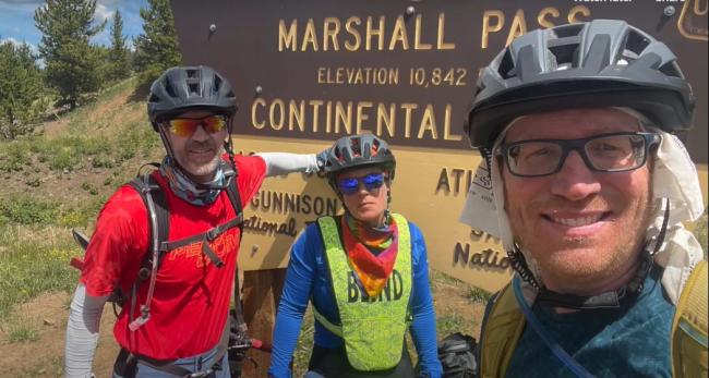 Jesse Crandall with Shawn Cheshire and Steve Martin posing with a sign on one of their trips.