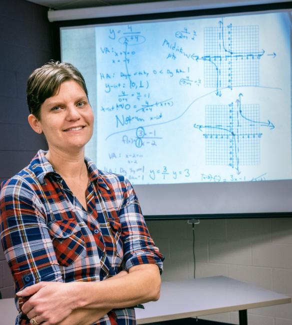 Jodi Dawson, standing in front of a screen with a math problem projected on it.