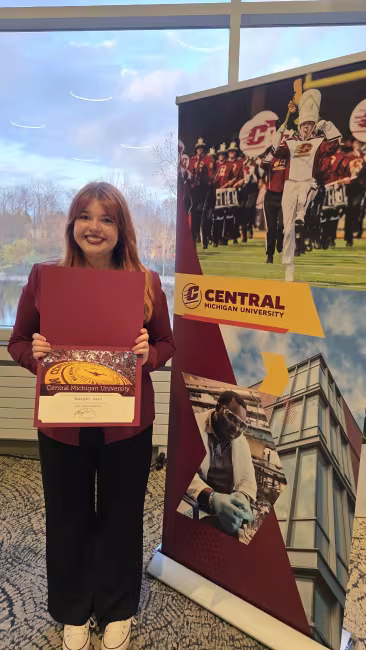 Karalynn Davis holds up her scholarship award.
