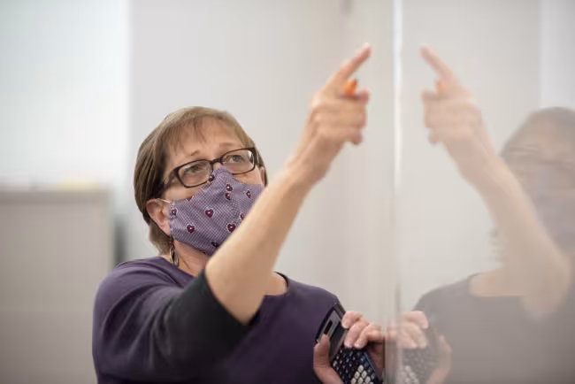 Barb Boothillier working at the white board in class.