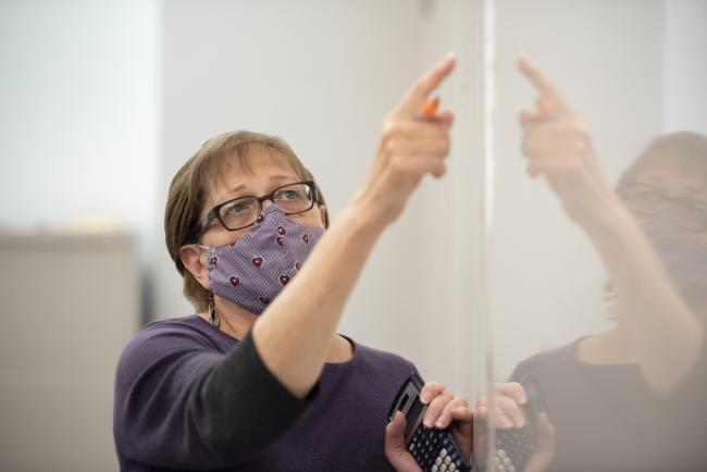 Barb Boothillier working at the white board in class.