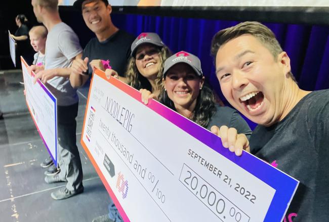 Chris Wessely and his team celebrate with a giant check after being named a winner.