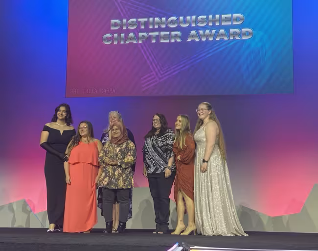 GRCC chapter members presented with one of their awards on stage.