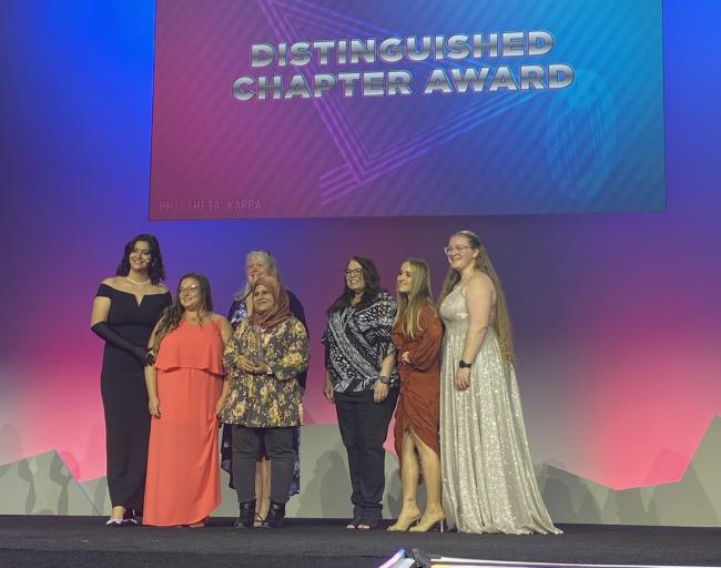 GRCC chapter members presented with one of their awards on stage.