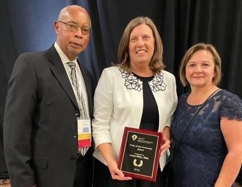 Linda Witte receiving her award. On her right is the President of the Board of Directors, Christopher Seay, and to her left is the Executive Director of AMT, Kathy Cilia.