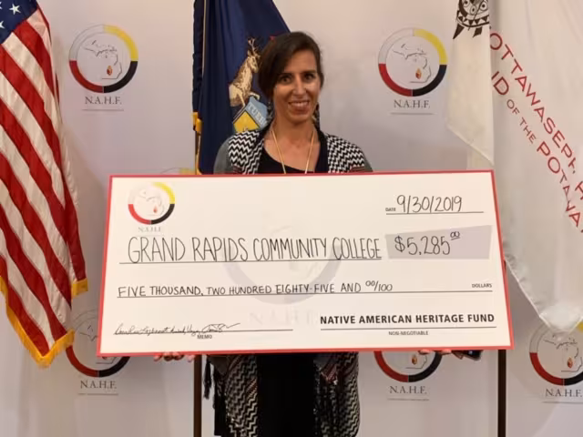 Rachel Beecher holds up a giant check for $5,285 from the Native American Heritage Fund.