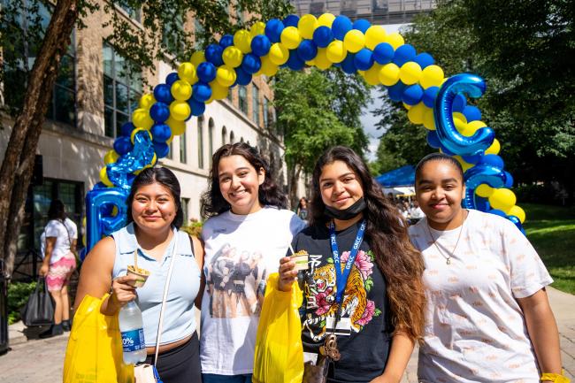 Students posing with a balloon arch during Raider Rally.