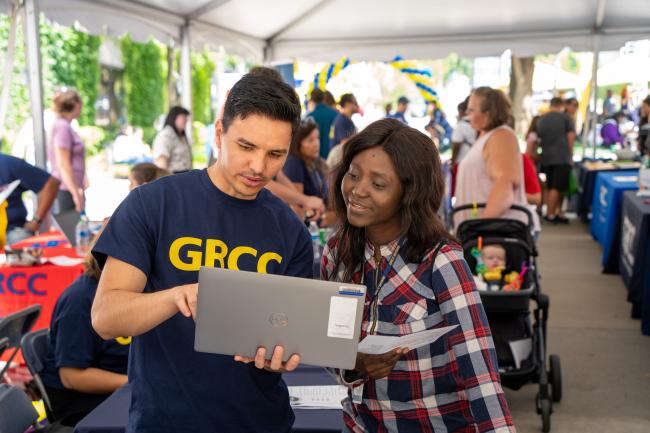 A GRCC specialist helping a student at Raider Rally.