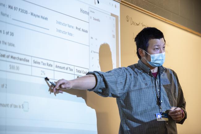 Wayne Hsieh teaching at a white board.