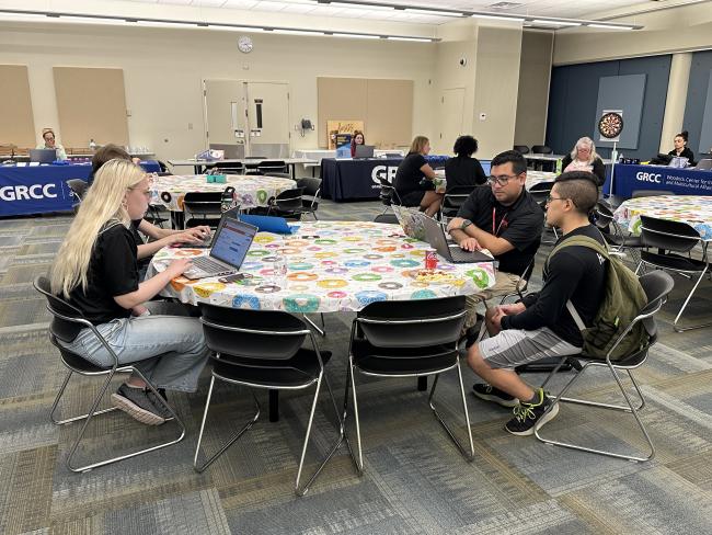 TRIO team members sit at a round table during a resource fair.