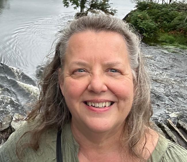 Humanities professor Tamera Detrick poses outdoors.