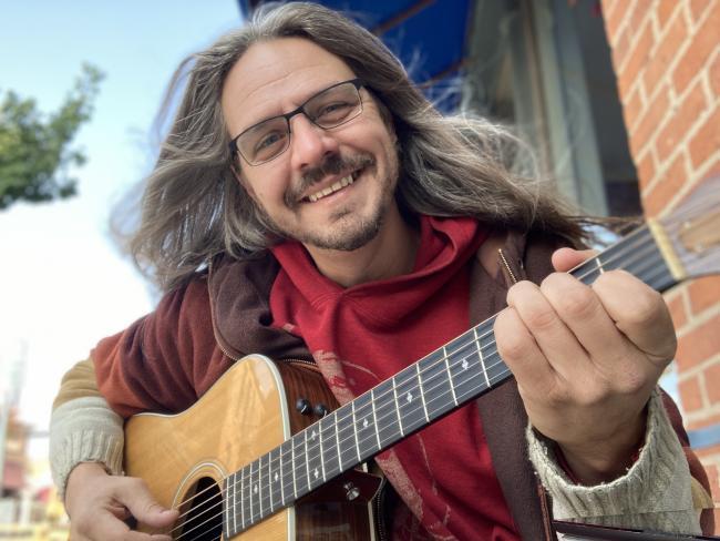 Nik Thomasma with his guitar.