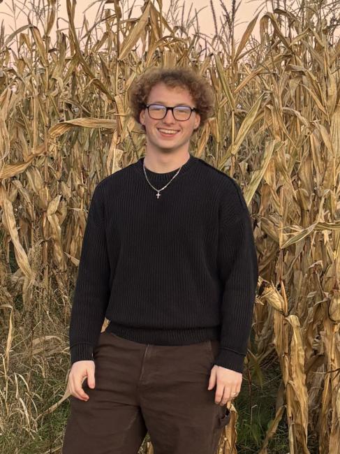 Tyler Watkins standing outside and smiling.