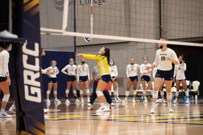 Volleyball action with a Raider setting the ball.