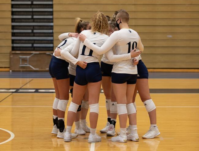 Volleyball players gather in a circle.