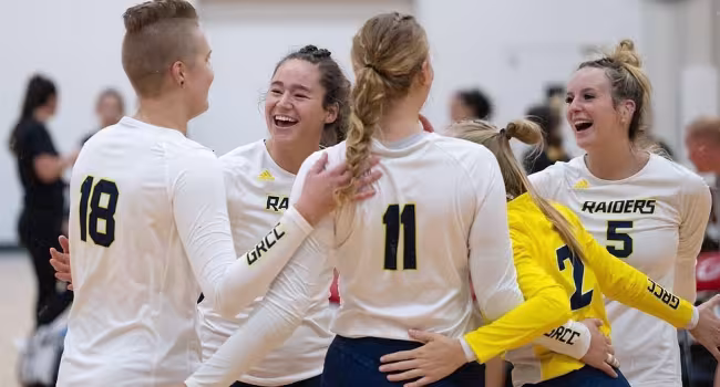 Volleyball team members celebrating after scoring a point.