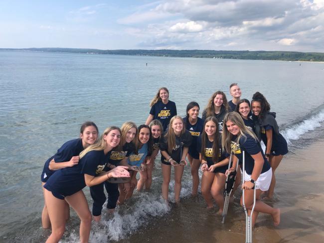 GRCC volleyball team members collecting Petoskey stones before their match.