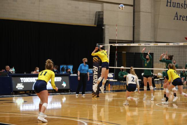 GRCC player leaping in front of the net for a spike.