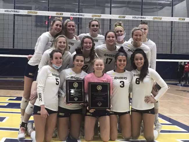 The volleyball team poses with championship awards.