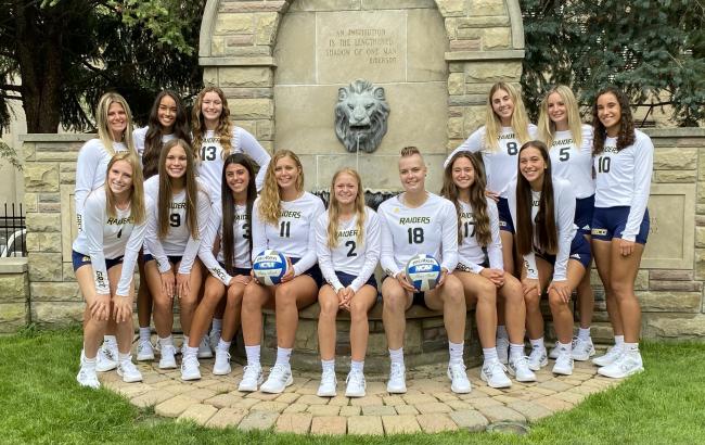 Volleyball team posing by the lion fountain.