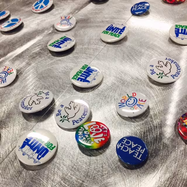 Peace buttons sit on a table.