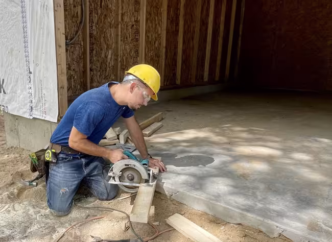 Joshua Middleton working with a saw on a construction project.