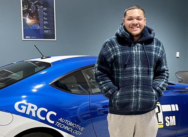 Kevin Rios posing with a car in the M-TEC.