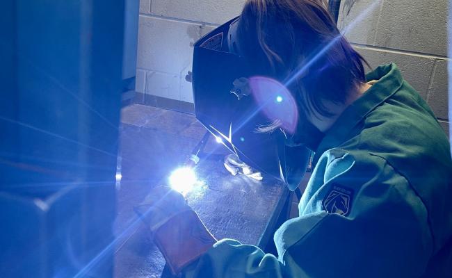 Marissa in the shop welding.
