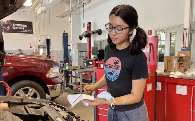 Nataly Ramirez working on a car.