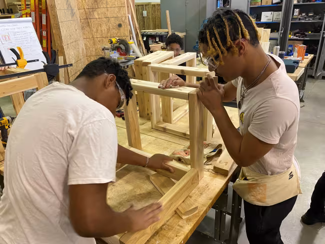 Zeke Grandy and Malik Campbell working in the wood camp.