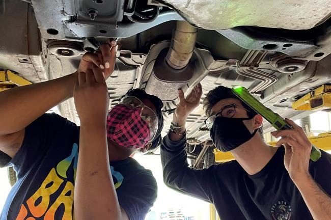 Indonesia Carpenter and Alex Estrada working on a car.