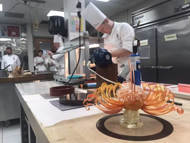 Chef preparing pulled sugar dessert in the competition.