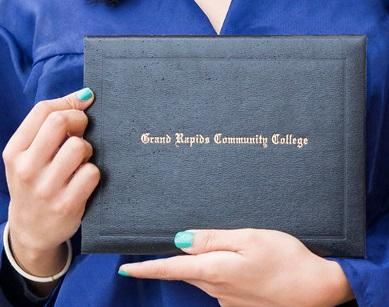 A student holds up a Grand Rapids Community College degree.