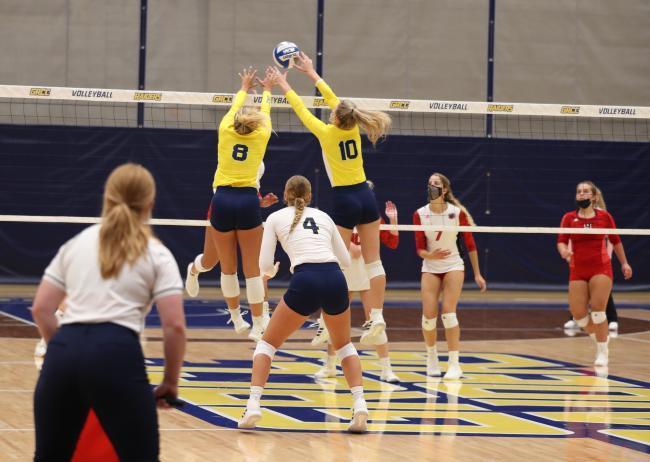 GRCC volleyball players jumping for a block.