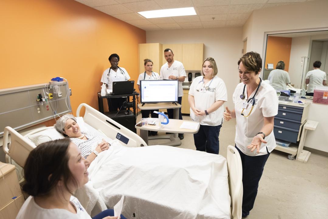 Nursing students in lab attending to a patient