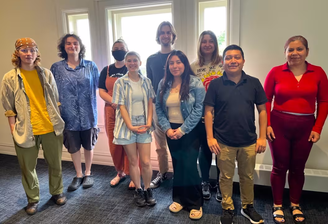 Nine people pose for a photo.