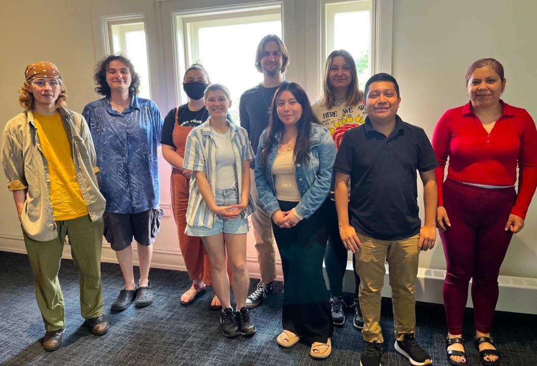 Nine people pose for a photo.