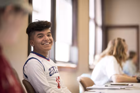 GRCC student smiling while listening to a lecture in a classroom