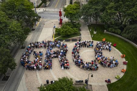 "GRCC" spelled out by hundreds of people standing in a plaza.