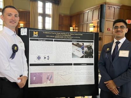 Two people stand in front of an academic research poster.