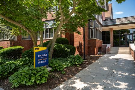 Exterior view of the GRCC Devos campus with a sign that says Sneden Hall and White Hall.