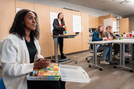 Students practice using colored blocks and other items in the classroom.