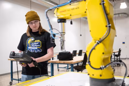 A GRCC student learns how to program a FANUC robot.