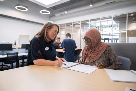 An advisor works with a GRCC student in the Lakeshore campus resource room.