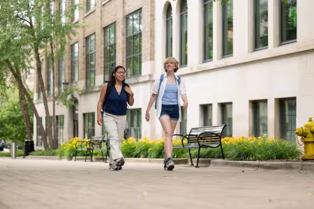 Two students walk together on campus.