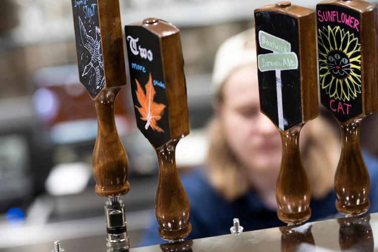 Four beer taps at Grand Rapids Fountain Hill Brewery show craft beer varieties available.