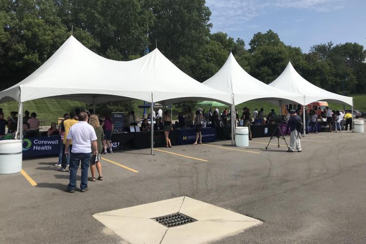 Job seekers talk with health care employers during an outdoor event.