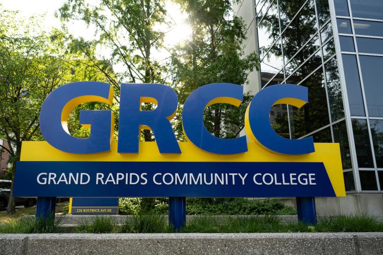 A blue and gold sign that says GRCC: Grand Rapids Community College is shown on campus.