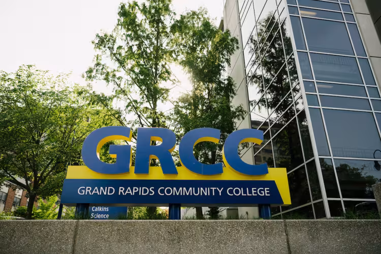 A blue and gold GRCC sign outside on campus