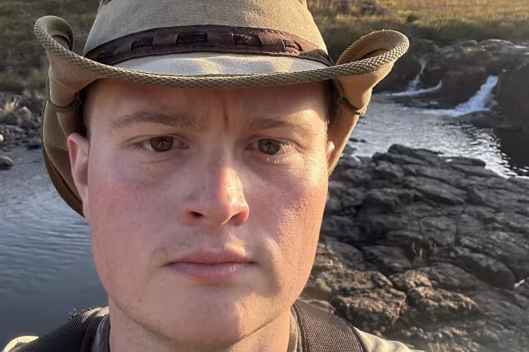 GRCC student Andrew Balcer pictured outdoors wearing a hat during his travels.